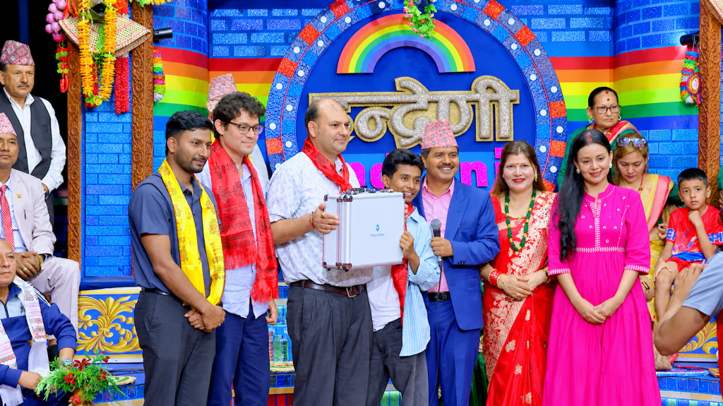 Krishna Kandel Indreni Foundation representatives presenting the Aarogya Health Monitor portable medical device during a community-focused event in Nepal.